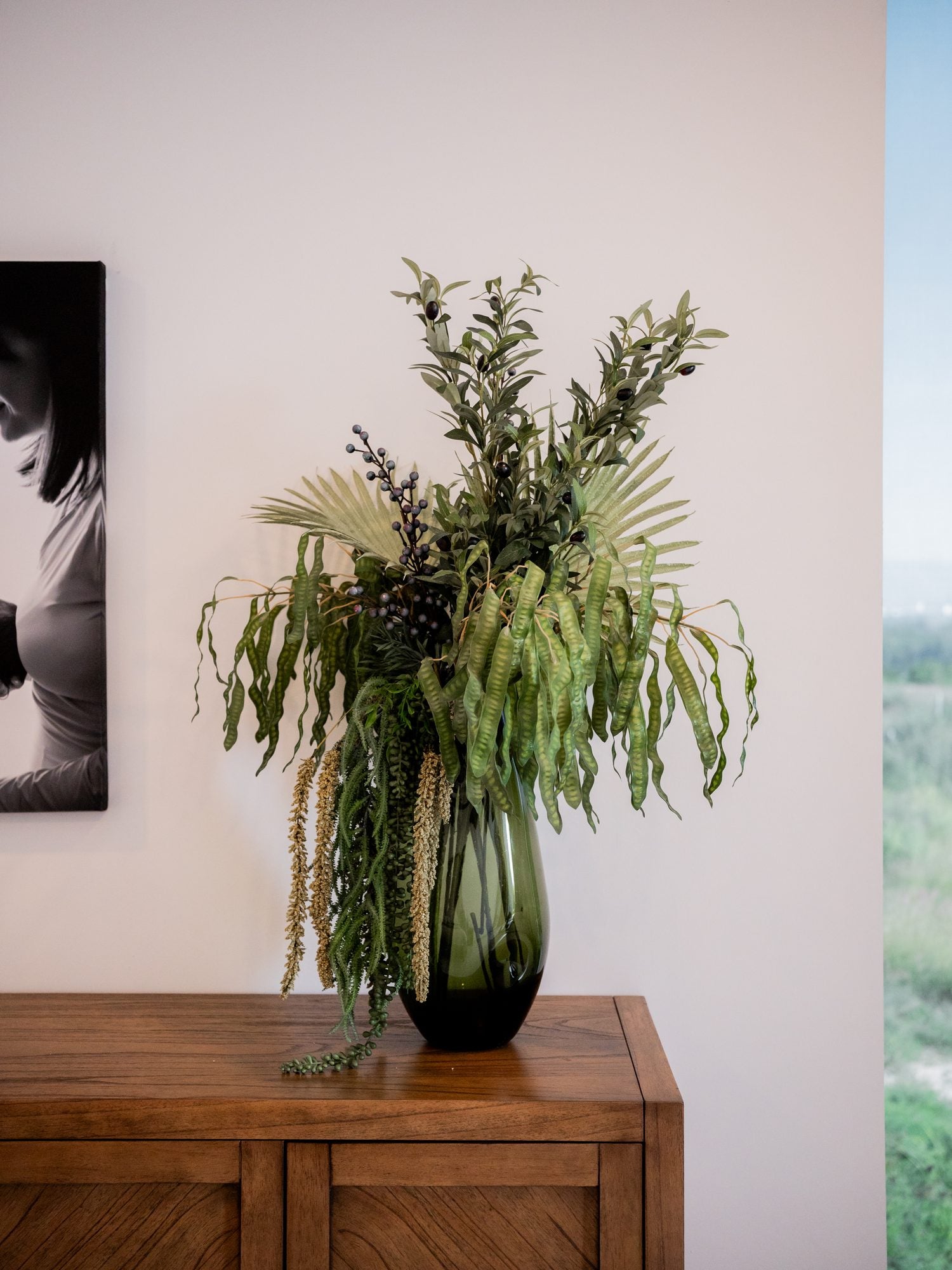 Composición botánica alta sobre un mueble de madera
