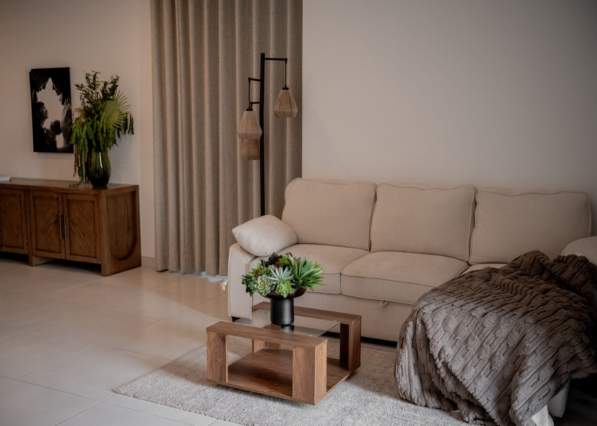 Composición botánica en una sala con sofá y mesa de madera